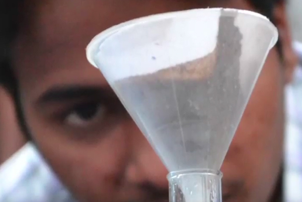 Scientist looking at soil in funnel