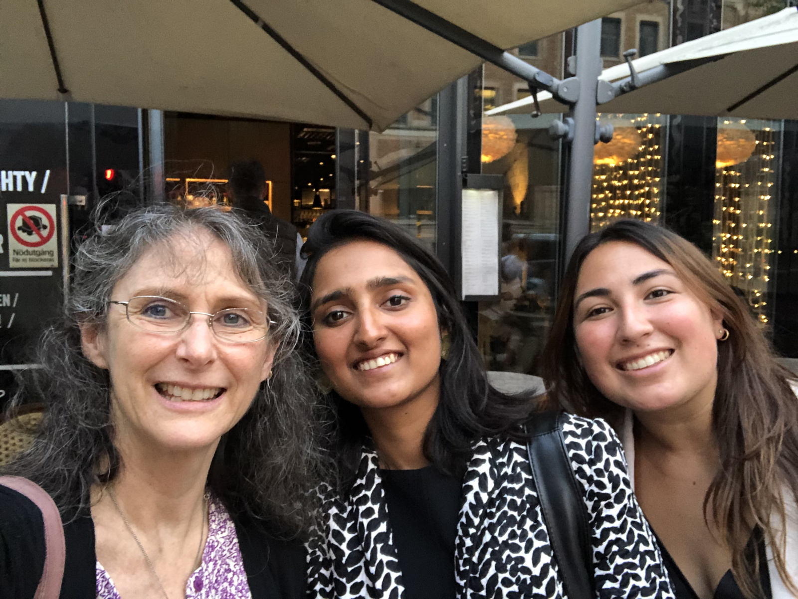 A selfie of Renee Robins (left), Shubhi Goyal (center), and Daniela Morales (right), in front of a restaurant