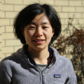 Jie Yun standing outside in front of a brick wall